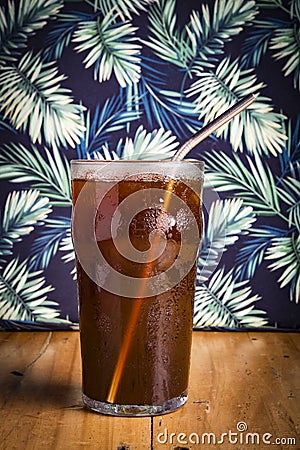iced espreso coffee drink with tropical green leaf as background Stock Photo