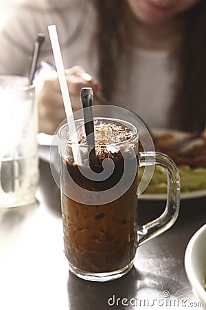Iced coffee with ice milk and straw in glass mug Stock Photo