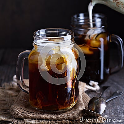 Iced coffee with milk in mason jars Stock Photo