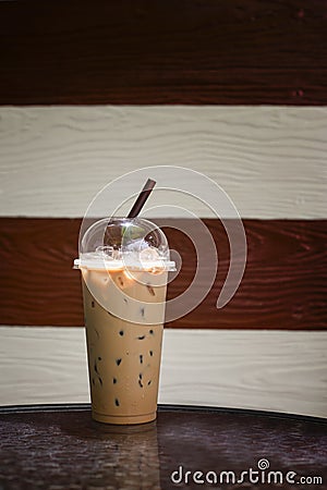 Iced coffee in takeaway cup on marble table with blurred two tone wooden in background,Selective focus,filtered image, dark Stock Photo