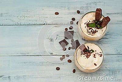 Iced Mocha Frappe Coffee with Whip Cream, Summer Drinking times. Coffee Beans. rustic textured Wooden Background. Mint Leaves Copy Stock Photo