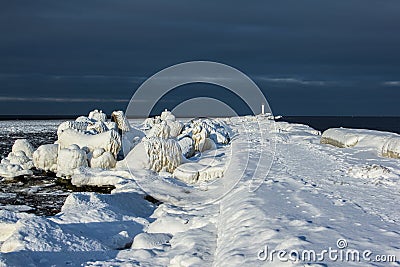 The iced over pier close up and Breakwater at sea bay Stock Photo