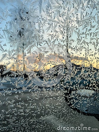 Iceflowers, frozen.The ice-cold frost forms ice crystals in beautiful unique patterns on the window, Hood and wiper on the Car Stock Photo