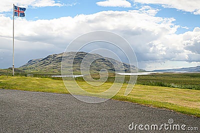 Iceland, 2008, June, Icelandic flag on a filed with a mountain in the background Editorial Stock Photo