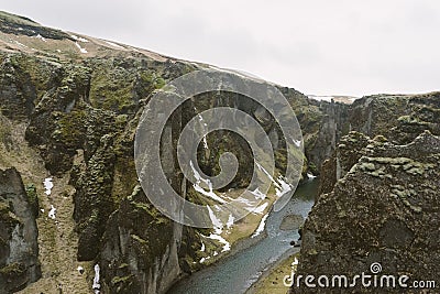Iceland landscape photography. Picture of gorge FjaÃ°rÃ¡rgljÃºfur Fjadrargljufur. Moody clouds in the background and a river. Stock Photo