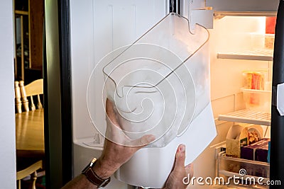 Man demonstrates how to remove an ice cube maker Stock Photo