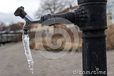 Icicle hanging from tap Stock Photo