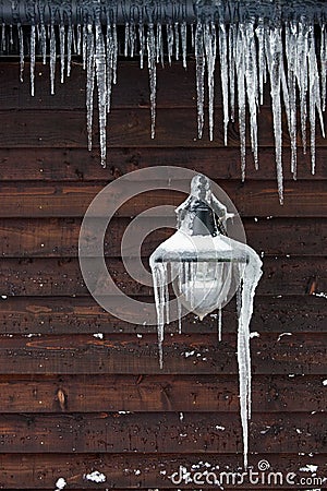 Icicles hanging from a lamp and drainpipe Stock Photo