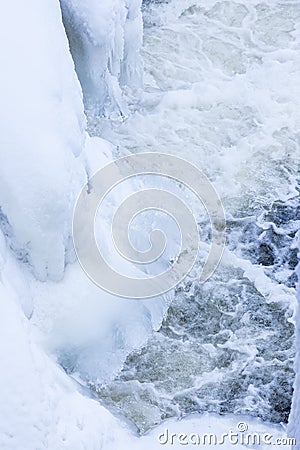 Icicles and snow near flowing water Stock Photo