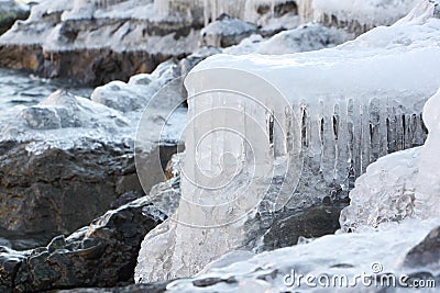 Icicles on stones at the thawing river Stock Photo