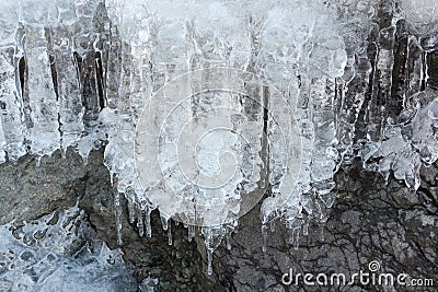 Icicles on stones at the thawing river Stock Photo