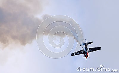 Extreme Aerobatics Extra EA 300L Aircraft in stunt Flight with dark sky bacground. Editorial Stock Photo