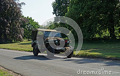 Vintage WWII-period 1944 Willys jeep on country road. Editorial Stock Photo