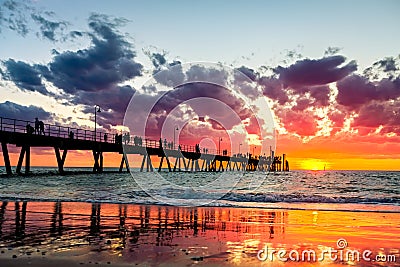Iconic Glenelg jetty with people silhouettes at sunset Stock Photo