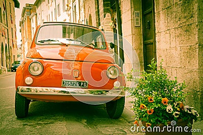 Iconic Italian car in grungy narrow street in small town. Editorial Stock Photo