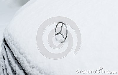 Iconic Mercedes-Benz logotype insignia covered with snow Editorial Stock Photo