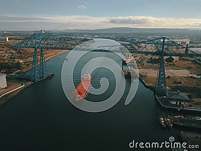 The iconic Teesside Transporter Bridge with a large ship passing under it. Editorial Stock Photo