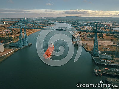 The iconic Teesside Transporter Bridge with a large ship passing under it. Editorial Stock Photo