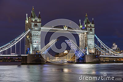 The iconic Tower Bridge in London at night, beautifully illuminated and with raised bascules Editorial Stock Photo