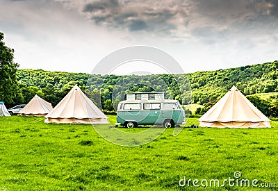 An iconic VW Camper or Kombi at a glamping site in the English countryside Stock Photo