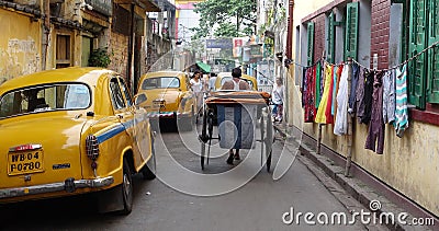 The iconic yellow ambassador taxi Kolkata and a hand pulled rickshaw Editorial Stock Photo