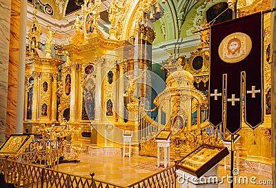 Icons, murals, angels and candles in the church. Golden Interior of Peter and Paul cathedral in Peter and Paul Fortress, St. Editorial Stock Photo