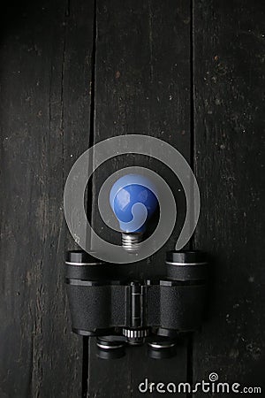 Idea concept. Blue Light lamp and vintage binoculars Stock Photo