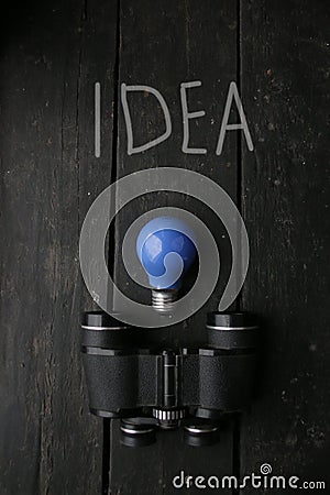 Idea concept. Blue Light lamp and vintage binoculars. Stock Photo
