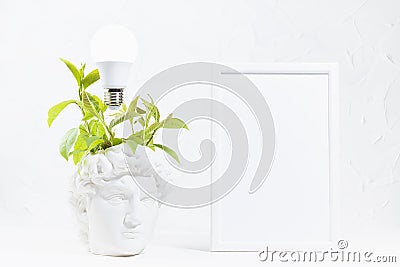 Idea concept with thinking head of antique statue David with fresh green wreath of leaves and glow light bulb over head, blank. Stock Photo