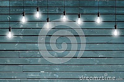 Idea concept - Vintage incandescent bulbs on blue wooden wall Stock Photo