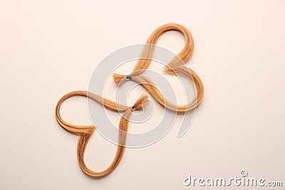 Hearts made of hair strands on light background. Concept of donation Stock Photo