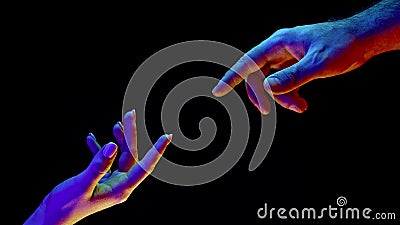 Idea of earth creation. Hands reaching out, pointing finger together on black and neon colorful light. Man and woman Stock Photo