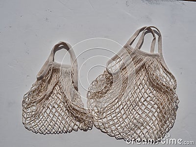 The idea of environmentally friendly products and bags.White reusable mesh bags of thread on a white background Stock Photo