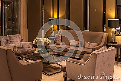 Modern luxurious lobby for hotel with comfortable sofas, arm chairs and moody lighting Stock Photo