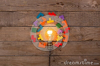 Idea and teamwork business concept, vintage incandescent light bulb and jigsaw on the wooden background Stock Photo