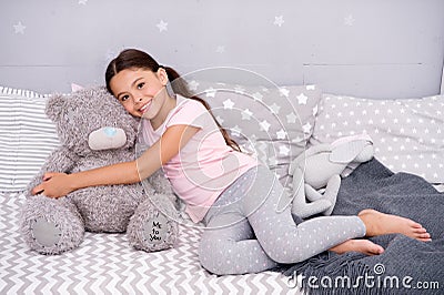 Ideal for cuddling. Happy child hold teddy bear toy in bed. Little girl play with soft toy. Toy shop or store. Nursery Stock Photo