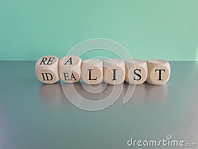 Idealist or realist. Turned wooden cubes and changes the red word 'idealist' to 'realist' or vice versa. Stock Photo