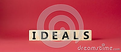 Ideals symbol. Wooden blocks with word Ideals. Beautiful red background. Business and Ideals concept. Copy space Stock Photo