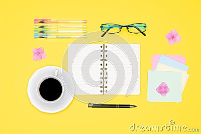 Top view photo of office desk with blank mock up open notepad, pen, glasses and cup off coffee on pastel background flat lay. Stock Photo