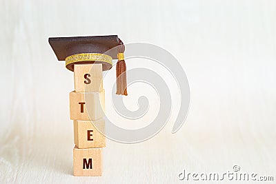 Ideas for STEM Education about science, technology, engineering, mathematics word on Graduation celebrating cap with wooden blocks Stock Photo