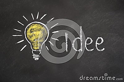 `Idee` text with an idea Light bulb on chalkboard. Translation: `Idea` Stock Photo