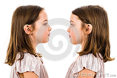 Identical twin girls are looking at each other and smiling Stock Photo