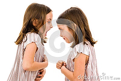 Identical twin girls sisters are arguing yelling at each other Stock Photo