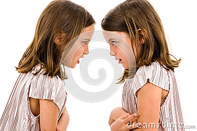 Identical twin girls sisters are arguing yelling at each other Stock Photo