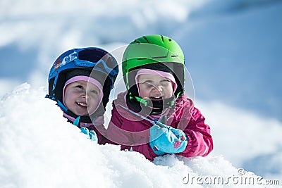 Identical twins are having fun in snow. Kids with safety helmet. Winter sport for family. Little kids outside,swiss Alps,mountains Stock Photo