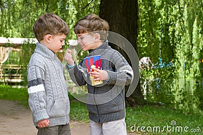 Identical twins with popcorn in the park Stock Photo