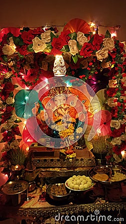 An idol of Ganpati Bappa decorated with flowers and served sweet Stock Photo