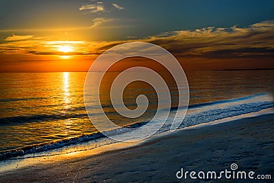 Beautiful dark orange idyllic sunset by the ocean Stock Photo