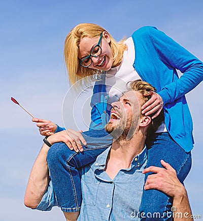 Idyllic date concept. Man carries girlfriend on shoulders, sky background. Woman enjoy perfect romantic date. Couple in Stock Photo