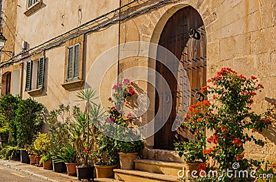 Beautiful front door with flower pots of a mediterranean rustic house Stock Photo